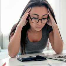 woman looking frustrated at her laptop