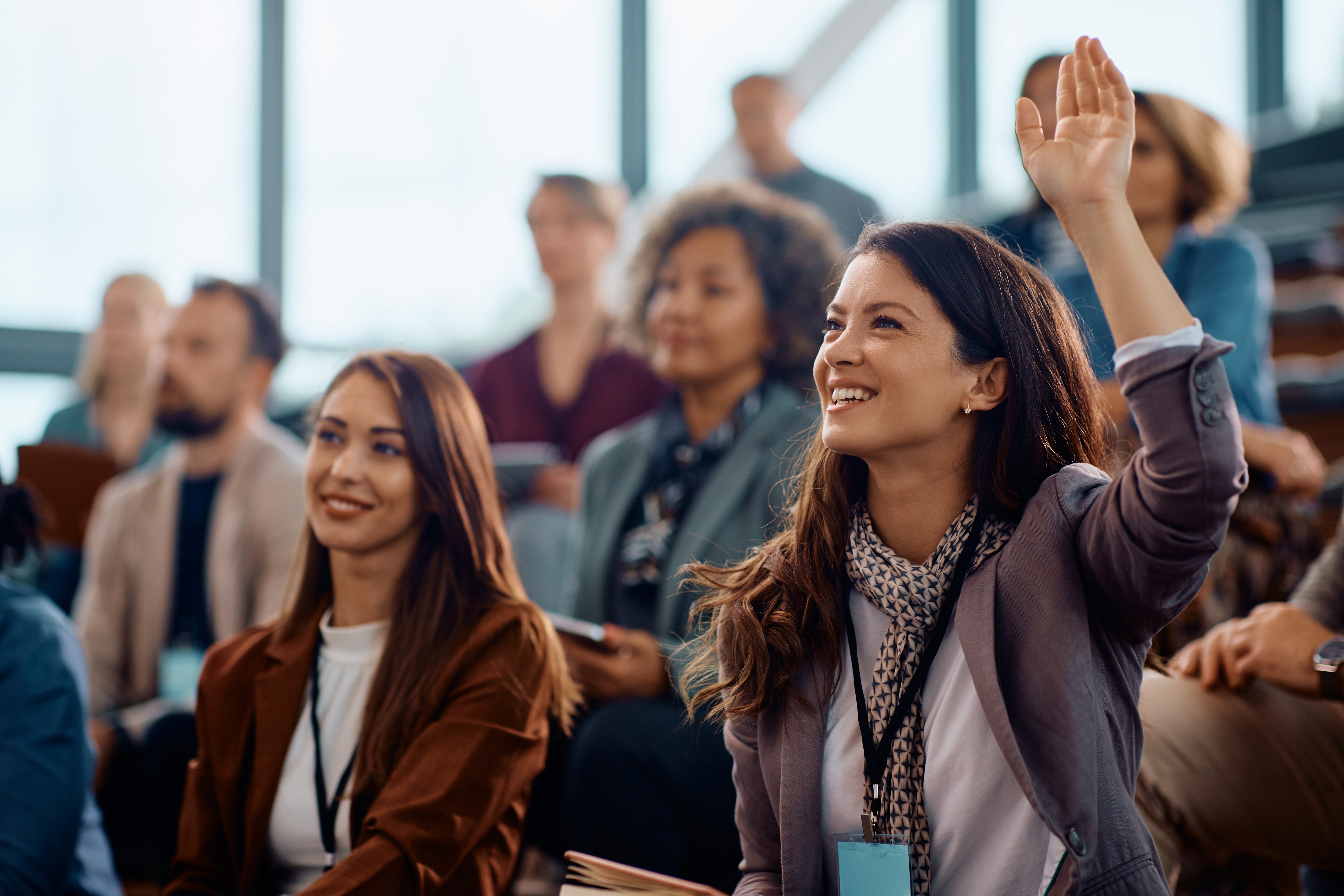 Woman in crowd raising her hand | What is employee engagement?